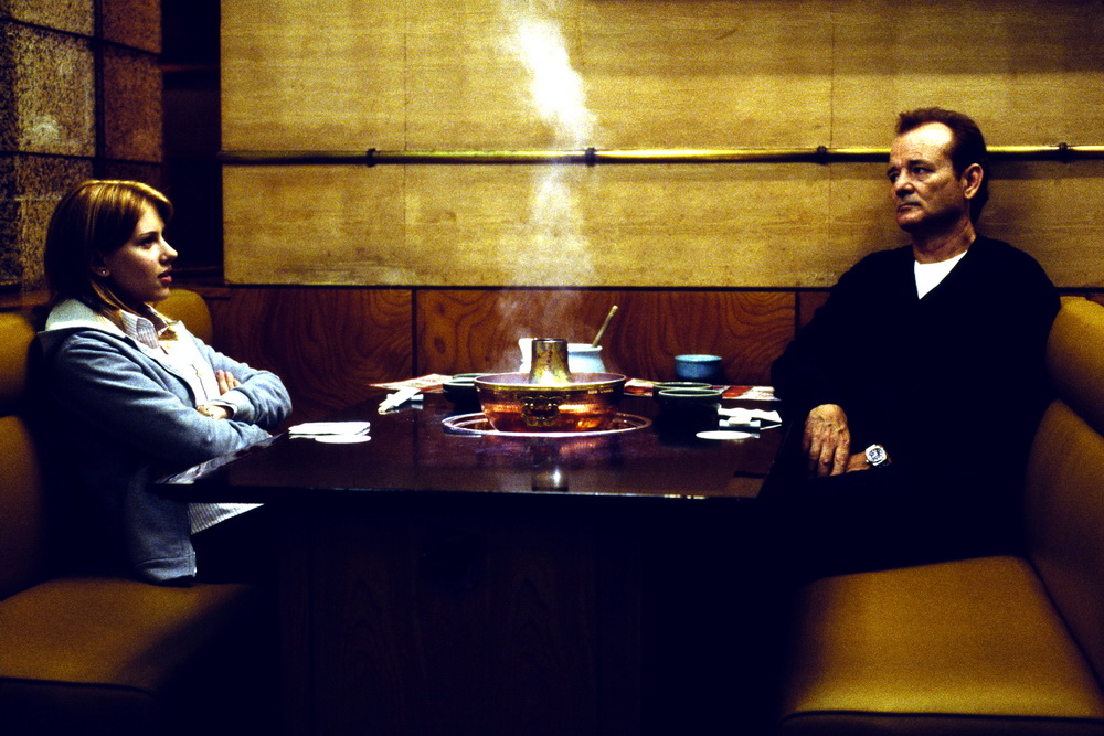 Szene aus Lost in Translation: Zwei Menschen sitzen um einen Tisch.